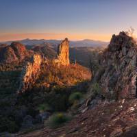 Sun rising over the Breadknife rock formation in Warrumbungle National Park. | Destination NSW