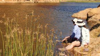 Two women relaxing at Glen Helen Gorge after a refreshing swim in the water