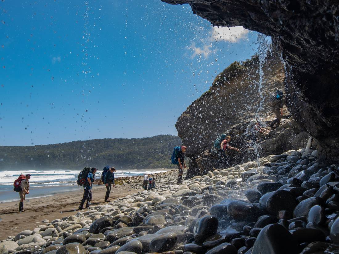 Trekking behind a waterfall on the South Coast Track |  <i>John Dalton</i>