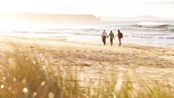 A couple walking on the beach on Bruny Island