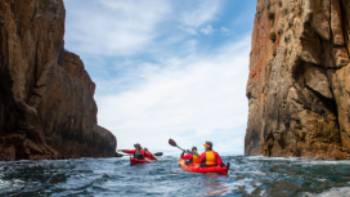 Kayak beneath dramatic scenery along the Tasman Peninsula