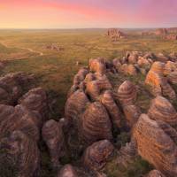 Indulge in the enchanting spectacle of a sunset casting its warm hues against the iconic Beehive Range in the Bungle Bungles | Tourism Western Australia